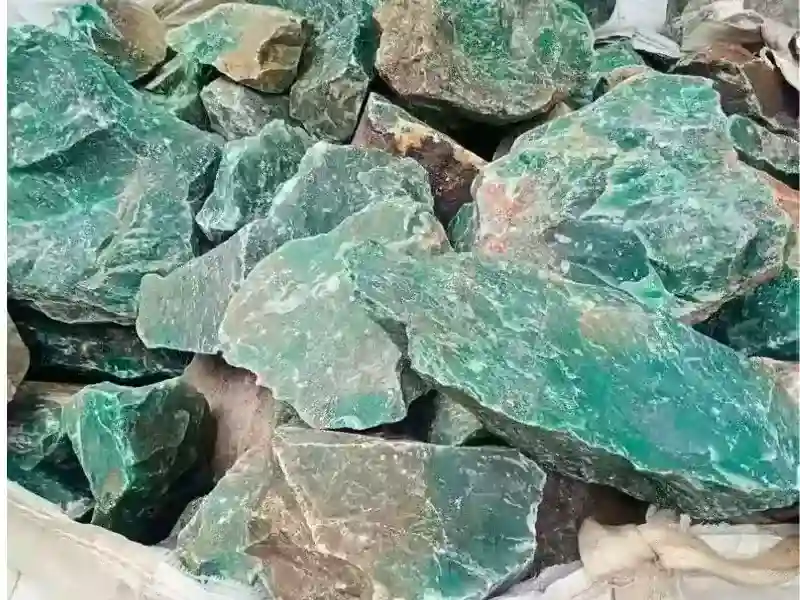 非洲翠原礦石堆疊圖,呈現石英質玉的天然外觀與礦色,與獨龍玉成分相近,為非洲翠價格低廉且可量產的關鍵來源。